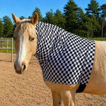 Horse wearing a black and white checkered faceless hood sleazy in an outdoor setting with trees in the background.