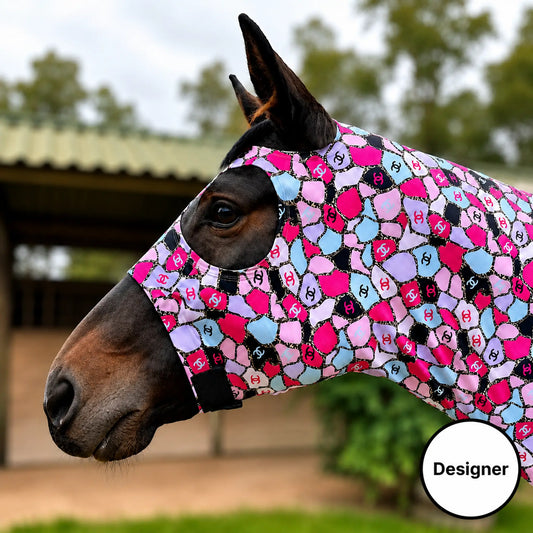 A close-up side view of a horse wearing a colorful COCO pink full body sleazy in an outdoor stable setting. 