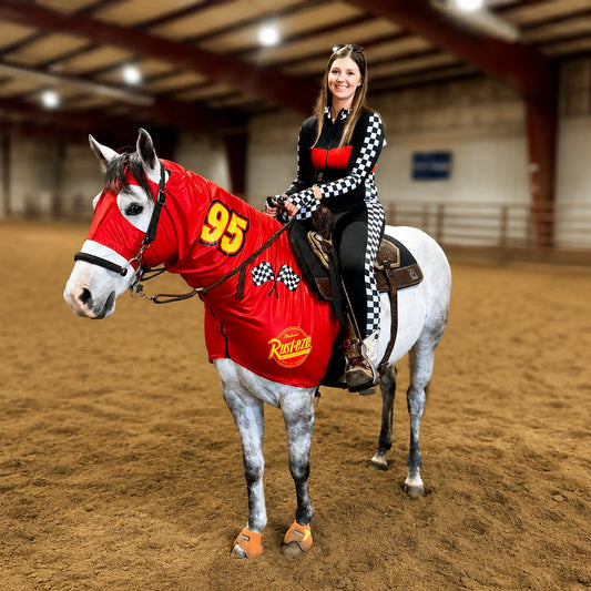 Woman riding a horse wearing a lightning McQueen costume sleazy with number 95 in an indoor arena.