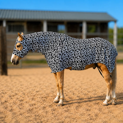 Horse wearing a black and white cow print costume sleazy in an outdoor setting