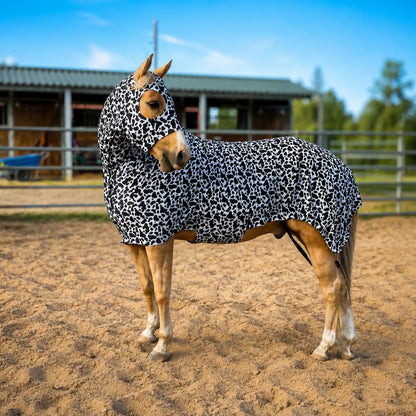 Horse wearing a cow print costume sleazy in an outdoor stable setting