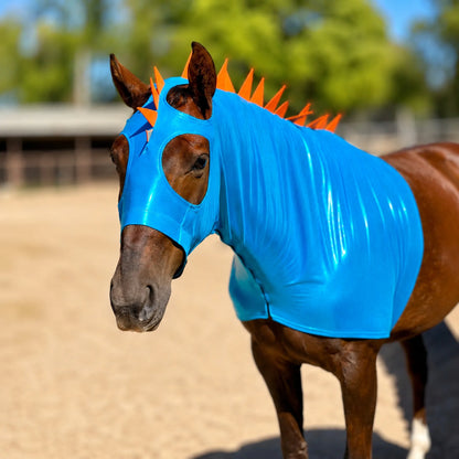 Horse wearing a metallic blue dragon costume with orange spikes and matching tailbag with spikes in an outdoor setting