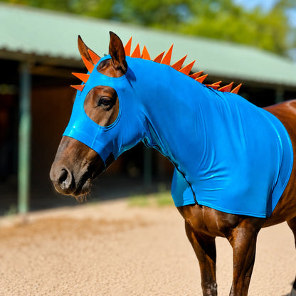Horse wearing a bright blue metallic dragon costume hood sleazy with orange spikes in an outdoor setting