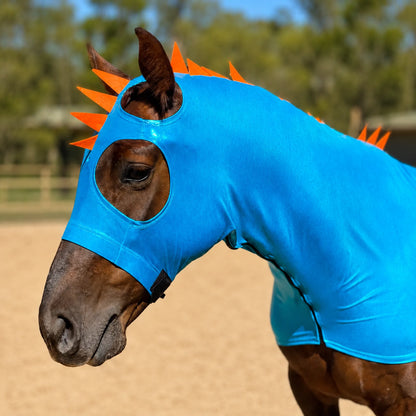 Horse wearing a metallic blue dragon sleazy hood costume with orange spikes in an outdoor setting