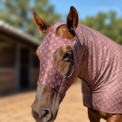 A brown horse wearing a LV brown sleazy hood, photographed outdoors in a stable with a blurred background.
