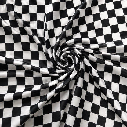Black and white checkered fabric draped in a spiral pattern, showing a smooth texture and glossy finish.