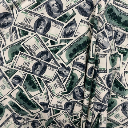 A close-up of a money print swatch pattern featuring a dense, overlapping print of U.S.