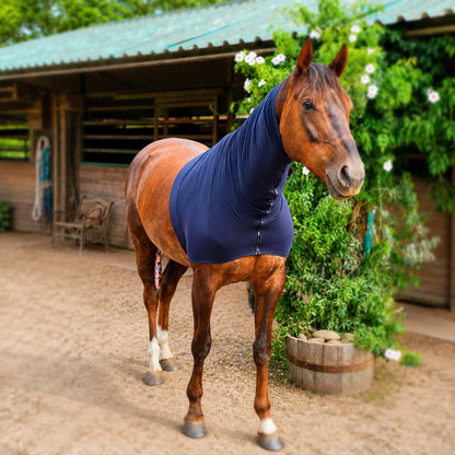 Horse wearing a heavyweight superflex black faceless hood standing in a stable area with greenery.